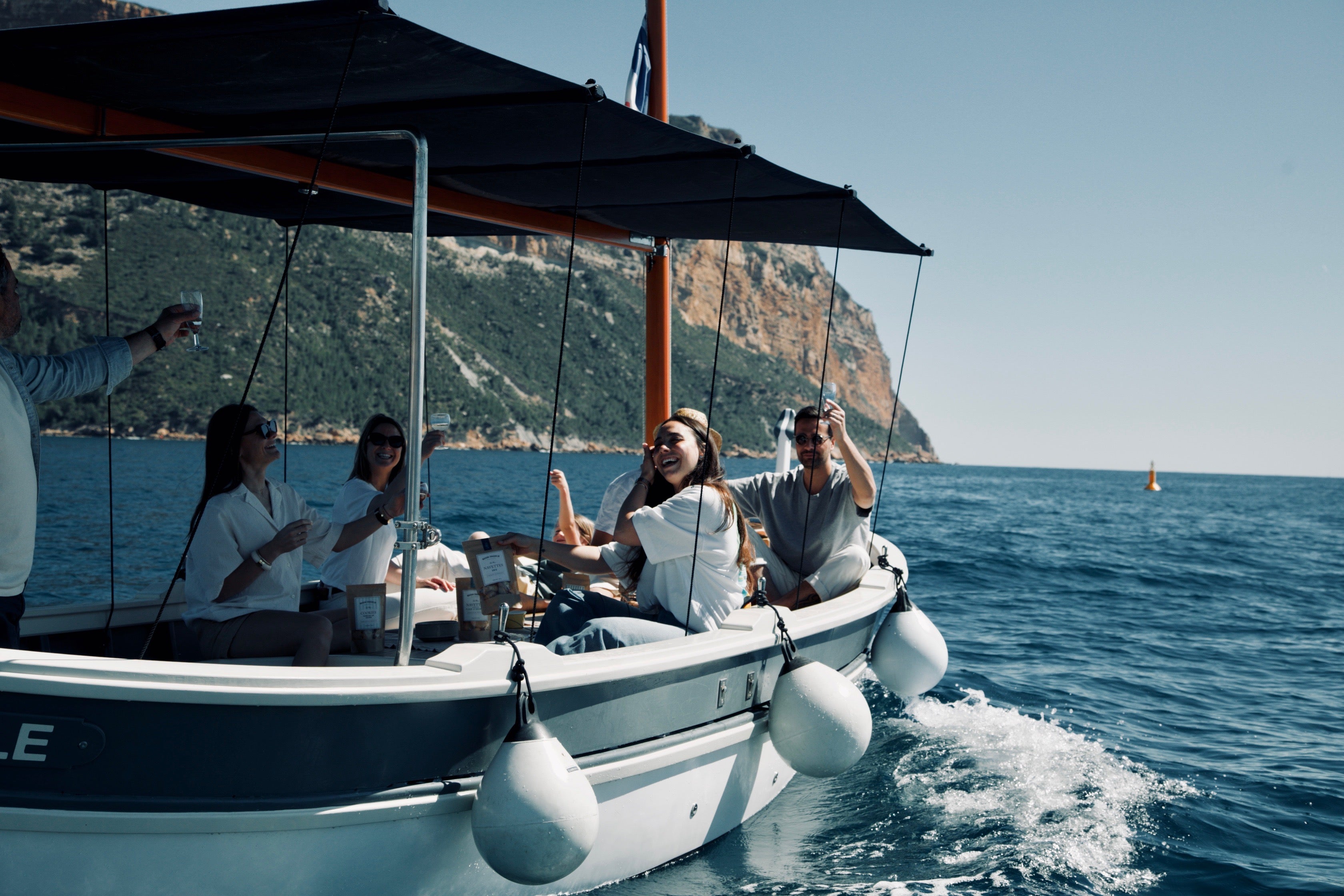 Pique-nique en mer entre amis au pied des falaises des calanques, avec les biscuits de Provence Maison Craquelin